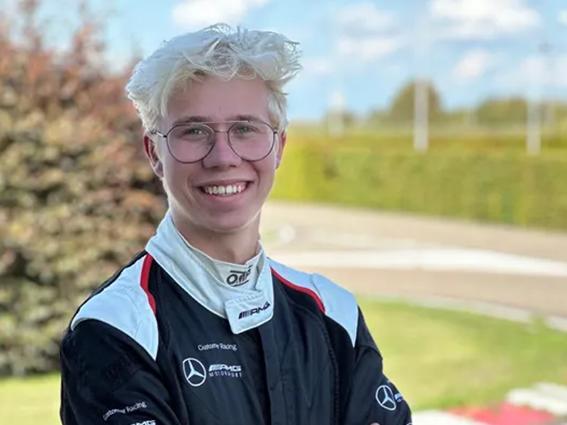 man in racepak bij racebaan