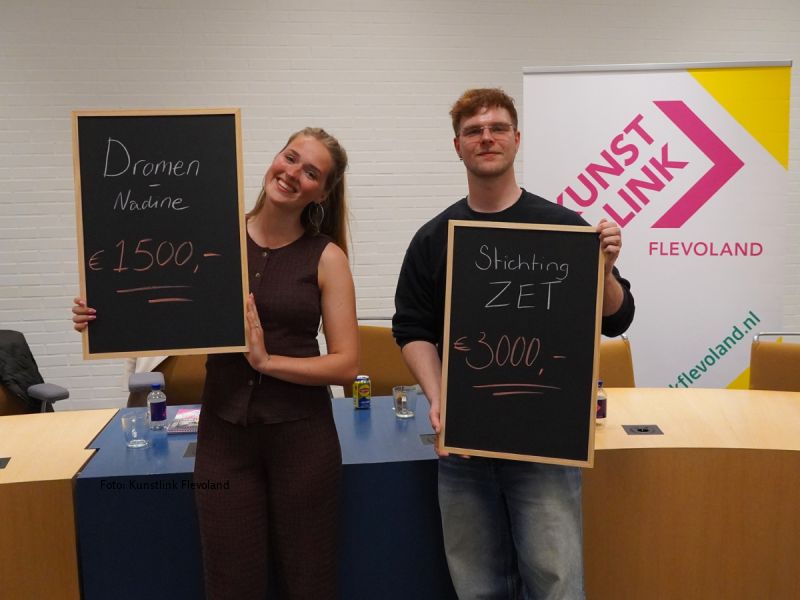 Nadine met haar bedrag op een krijtbord en Maarten van ZET ook, beide in de raadszaal naast elkaar