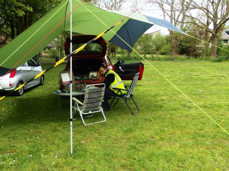 Man onder tent met radioapparatuur