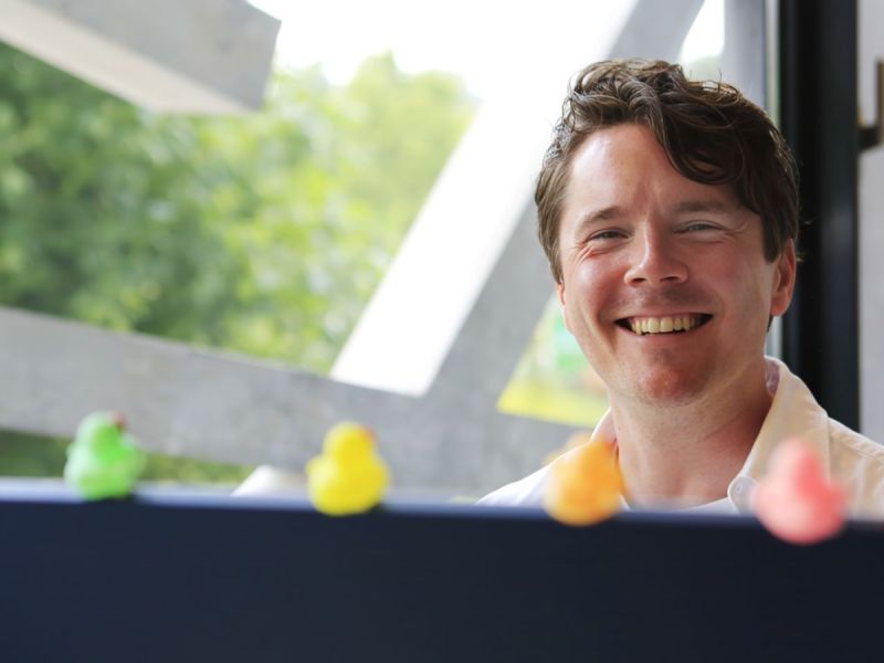 Teunis Ruiten achter een muurtje met wat kleine badeendjes in verschillende kleuren