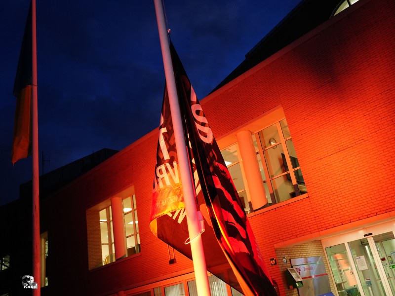 Vlag voor campagne wappert in oranje licht bij gemeentehuis Zeewolde