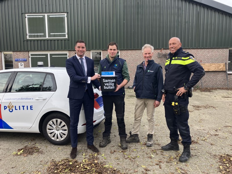 Mensen op foto met emmer met tekst naast politieauto