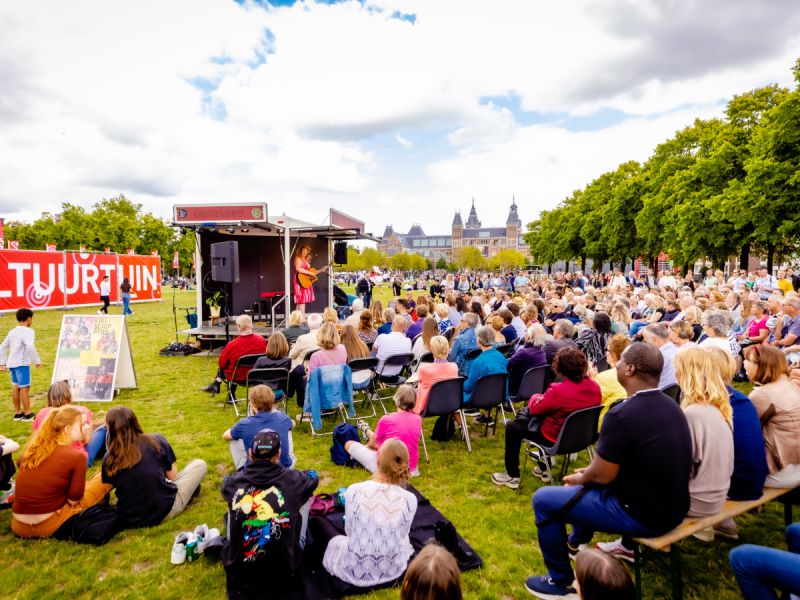 Een voorbeeld van een klapstoel cabaret op een andere locatie waar mensen op stoelen en banken naar een pop up podium mijken