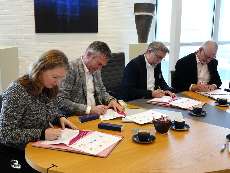 De partners aan de tafel in de raadszaal, allemaal tekenen ze de afspraken