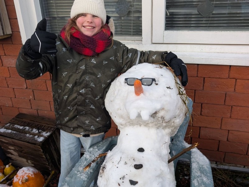 Foto van kind met sneeuwpop met zonnebril op.