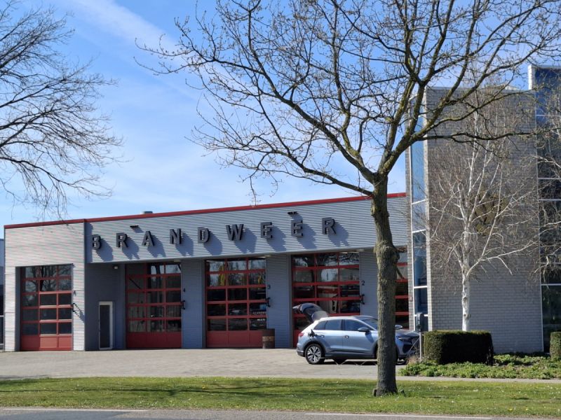 De brandweerkazerne waar ook een auto staat te laden