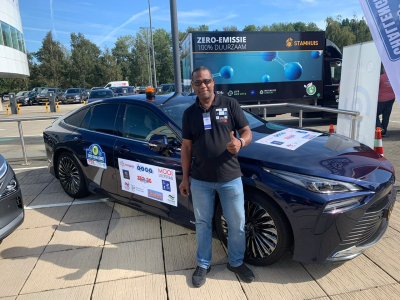 Man staat voor waterstofauto.