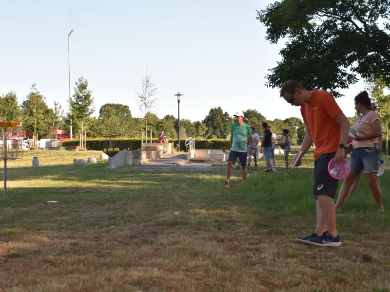 Mensen die voor de basket staan en de frisbee erin willen gooien, ze staan nog beetje opgelijnd