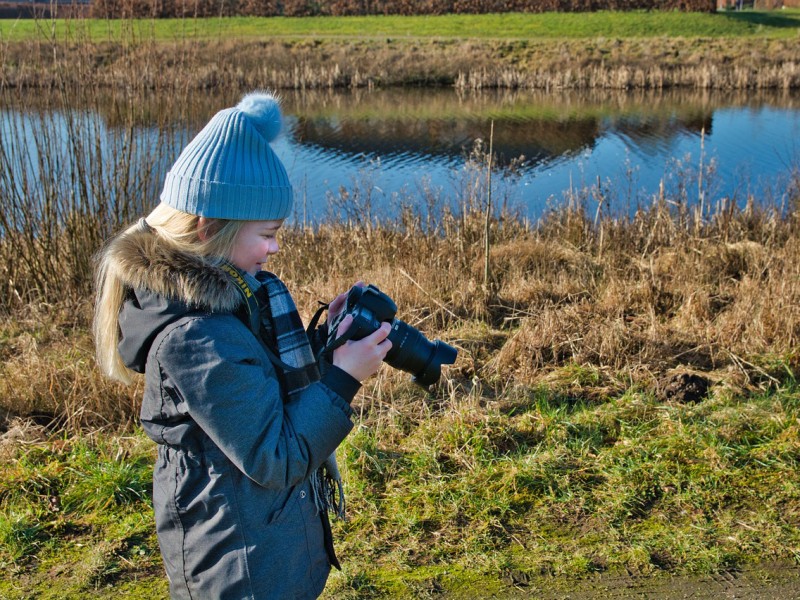 Kind maakt foto's in de natuur