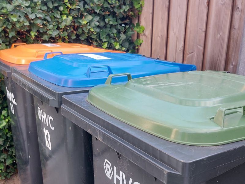 3 containers op een rij van oranje, blauw en groen