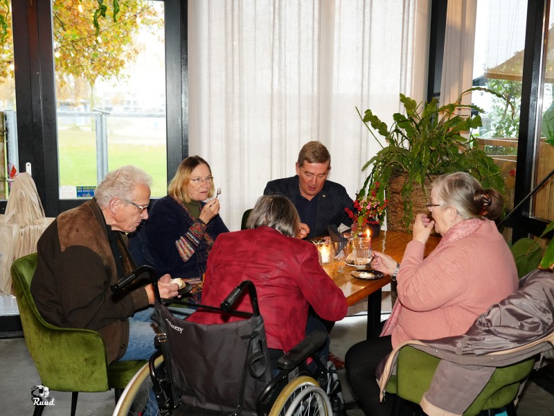 Mensen zitten aan tafel en spelen een spelletje.