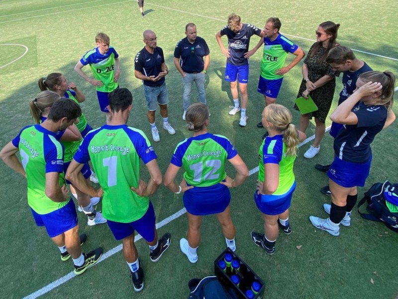 Het korfbalteam in een kring bij elkaar voor een overleg