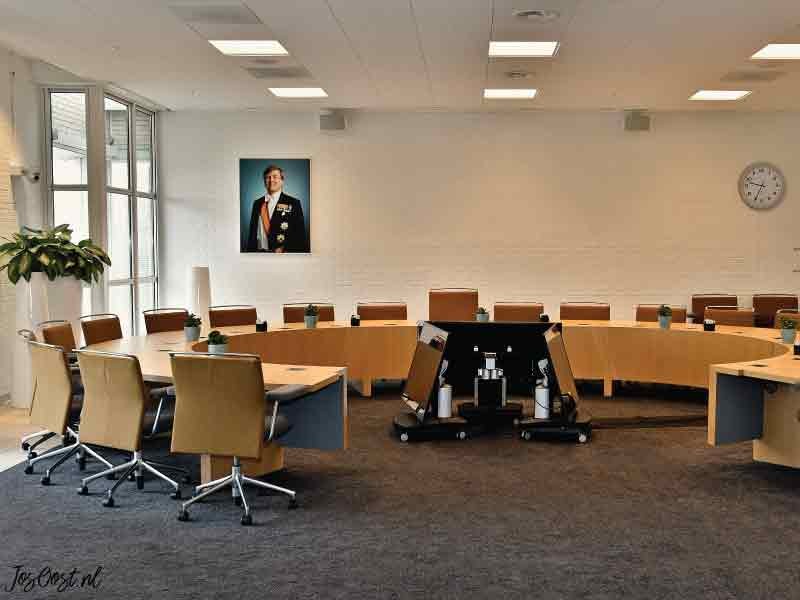 Raadzaal met ronde tafel en stoelen.