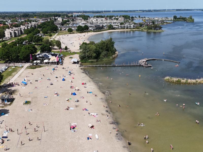 Het strand bezet met allerlei mensen en ook menen in het water