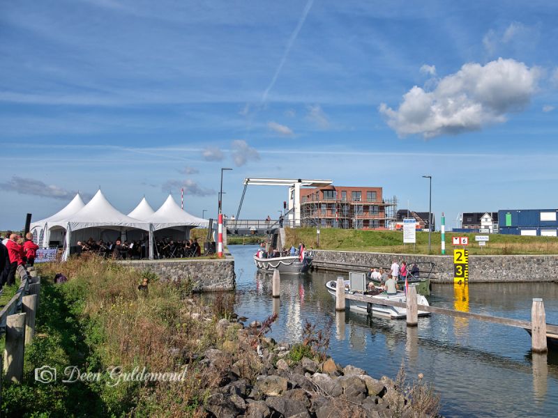 Bij het sluisje een tent waar muziek wordt gespeeld, publiek kijkt en boten langs varen