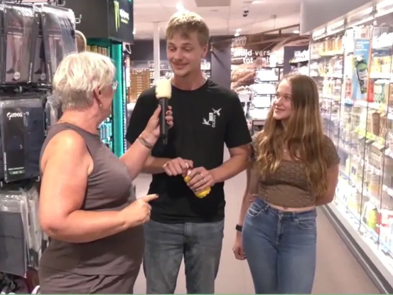 De winnaars met José in gesprek in de supermarkt over hun prijs