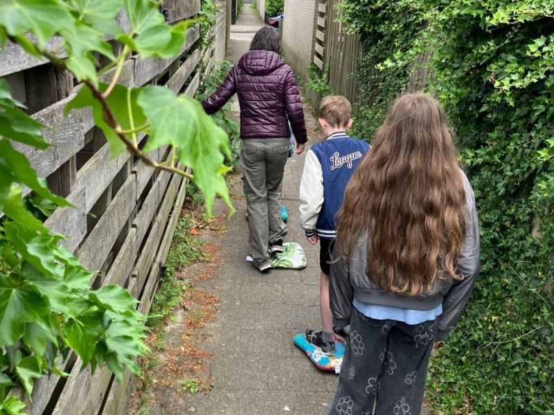 Familie speelt spel 'de vloer is lava' op kussentjes naar de ijssalon.