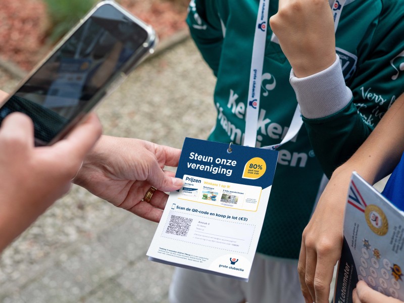 Iemand scant een QR code vanaf een papier met een telefoon.