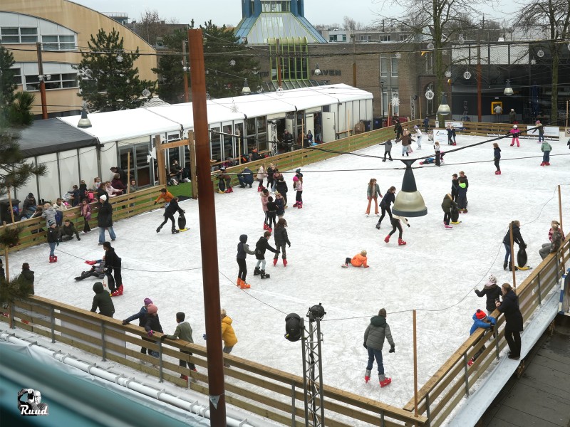 De ijsbaan op het Kerkplein, met allerlei schaatsende kinderen aan de kant