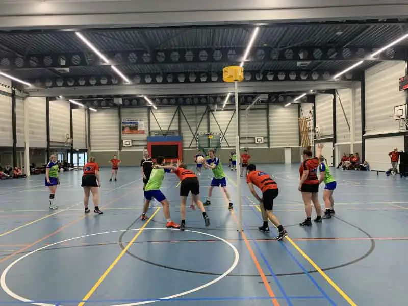 Beide teams spelend in de zaal rondom de korf