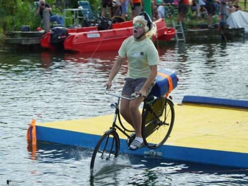 Een deelnemer van fiets m er in in het water