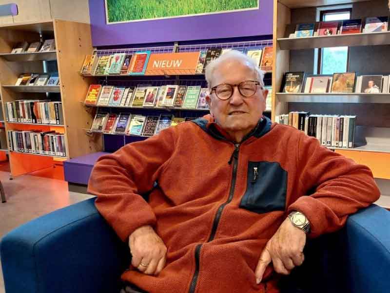 Theo van lint in een stoel in de bibliotheek