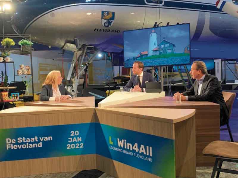 Panel van Economic Board in een studio in het Aviodrome, 1dame en 2 heren achter een tafel