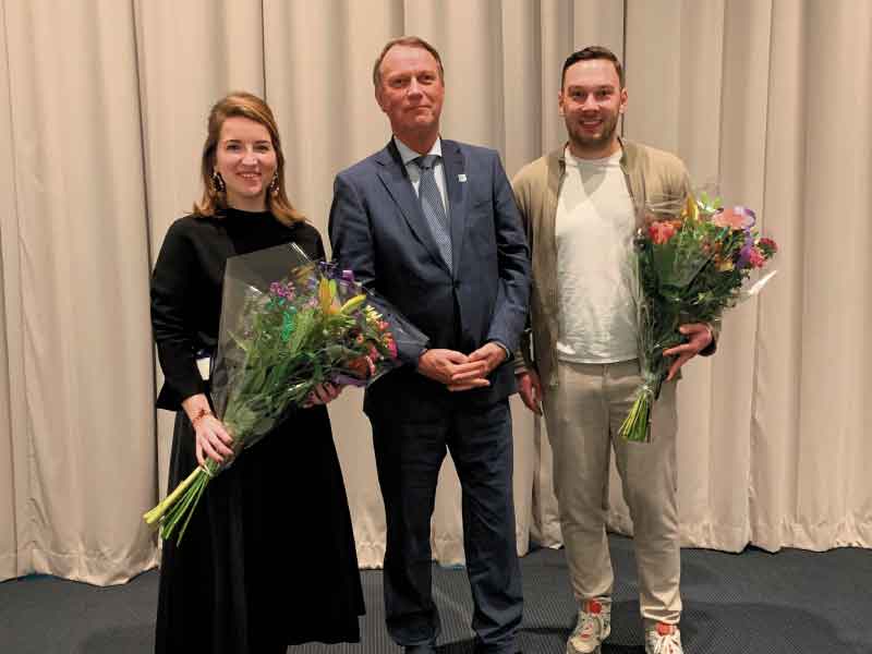 Gedeputeerde Jan de Reus overhandigt bloemen aan Merel Rozier (Sweco) en Wouter Giessen (TripService).  