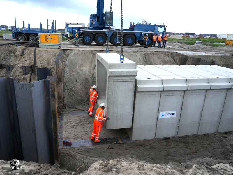 De elementen worden achter elkaar geplaatst, 2 bouwvakkers begeleiden het element voor positiebepaling