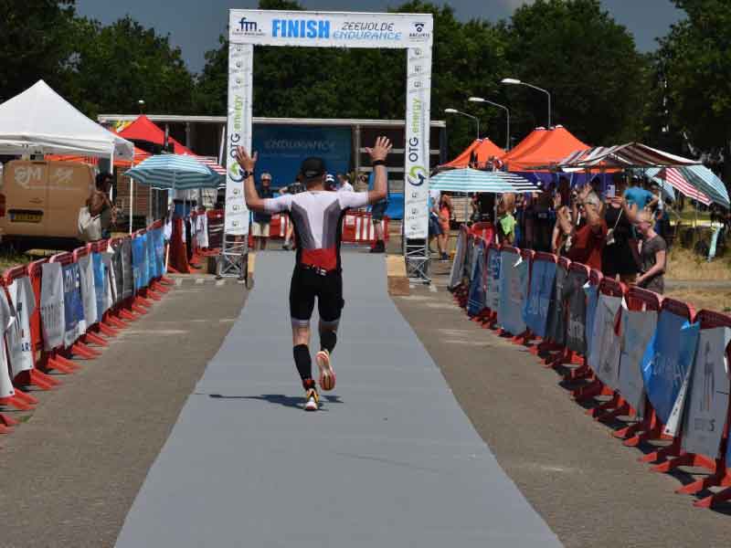 De finish bij de endurence een van de lopers gaat er juichend onder door