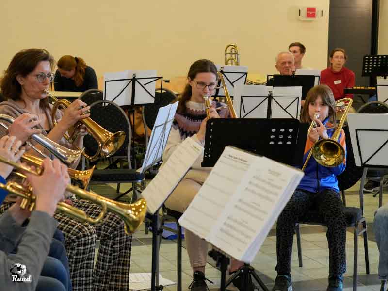 Kinderen en volwassenen die op blaasinstrumenten spelen