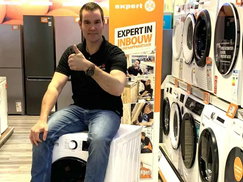 Erik van de Expert zit op een wasmachine