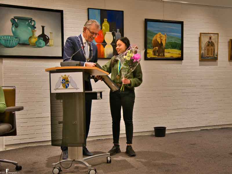 Burgemeester Gorter met McKayla in de raadszaal waar hij het lintje overhandigd