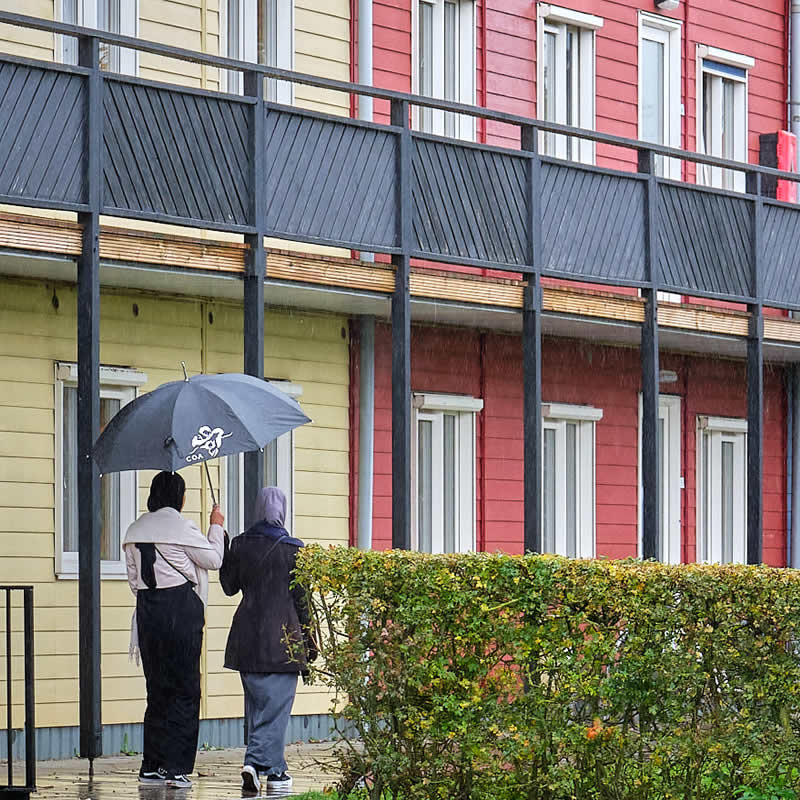 twee bewoners van het AZC in Zeewolde wandelen door de regen