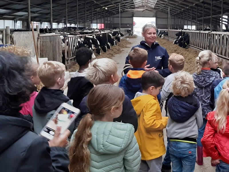 kinderen luisteren aandachtig naar de boerin