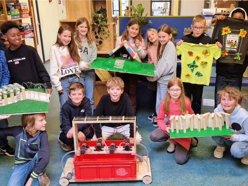 Een groep kinderen met allemaal projecten met ideeen in hun hand