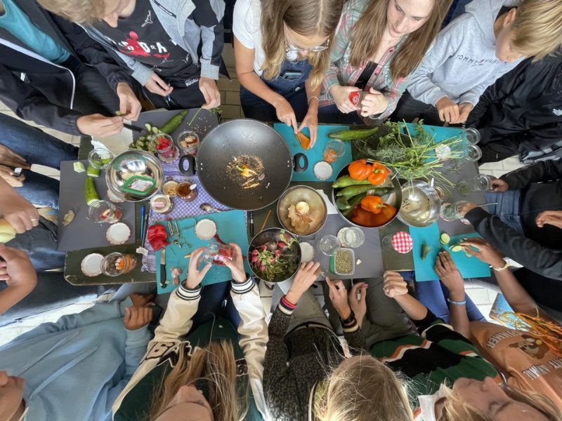 groep scholieren boven een tafel vol voedsel