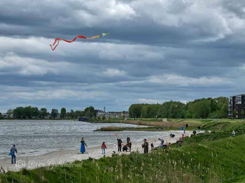 Tijdens het vliegerfestijn bij het Lanterstrand een vlieger in de zwaar bewolkte lucht