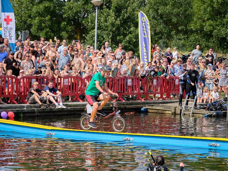 man op fiets die de over een parcour fietst om de overkant te halen