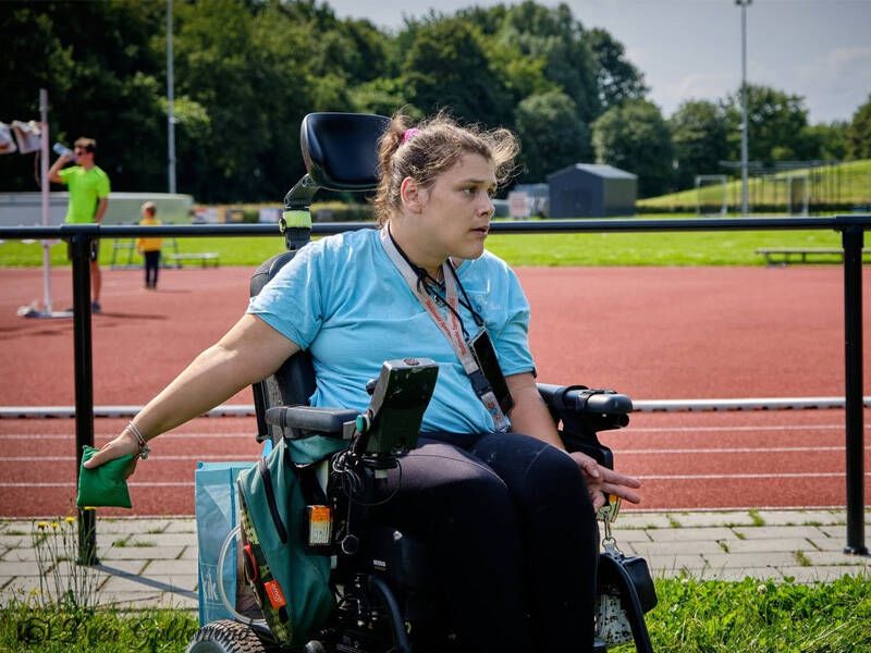 jonge dame in een roelstoel die een spel speelt