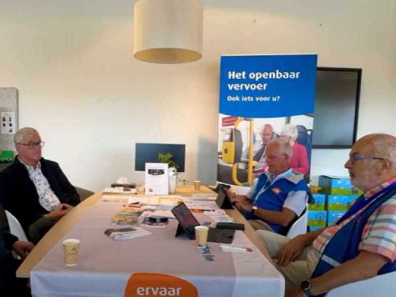 De OV Ambassadeurs aan een tafel met een "klant" in het Vraaghuis tijdens het spreekuur