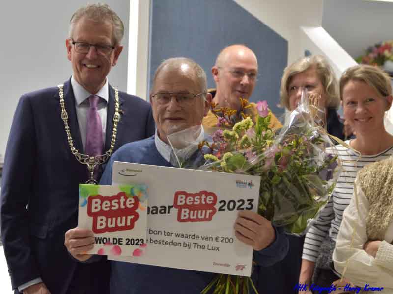 Theo met cheque, bloemen en burgemeester Gorter en buren om hem heen