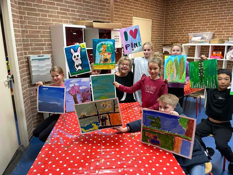 Kinderen met hun kunstwerk die ze laten zien