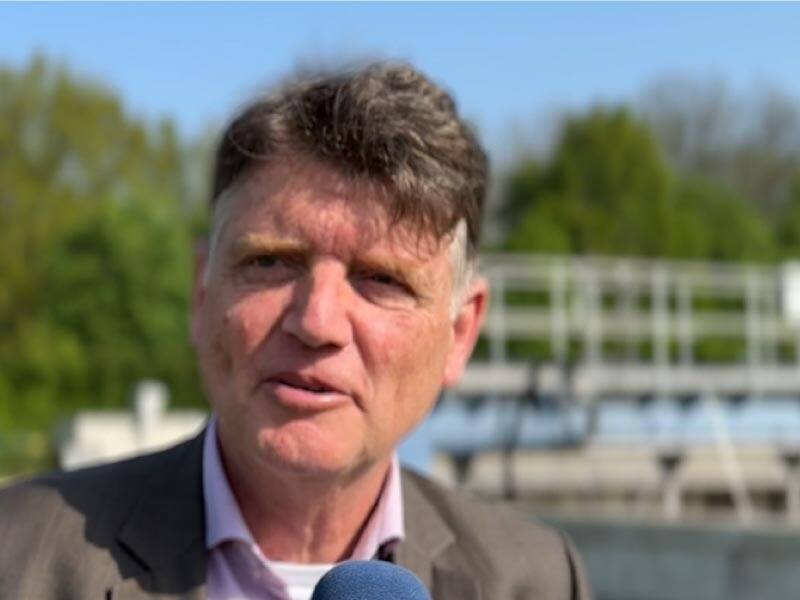 Jo Caris met op de achtergrond het waterzuiveringsbedrijf