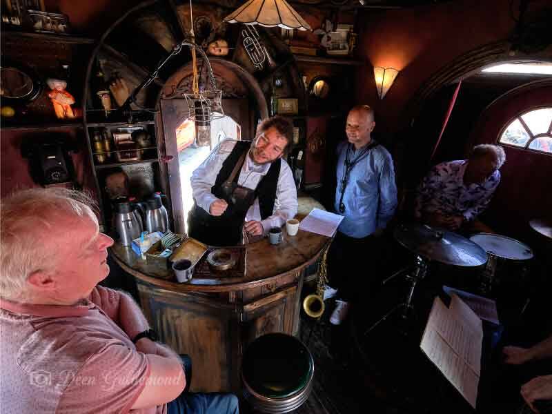 Mannes Schoppink met de barman en assistentie in de kopstootbar