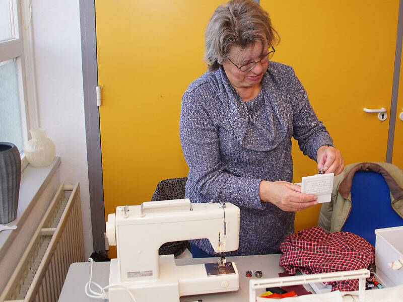 Vrouw die opzoek is naar  een spoel voor de naaimachine