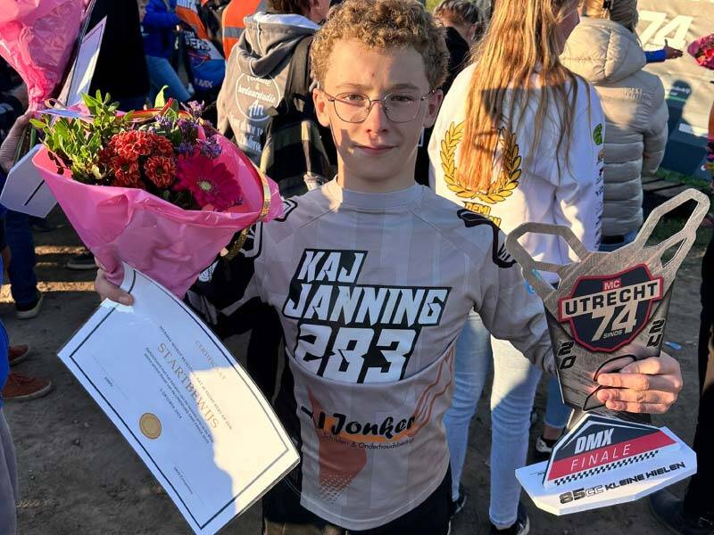 Kaj Janning met de beker, certificaat en bloemen in de handen