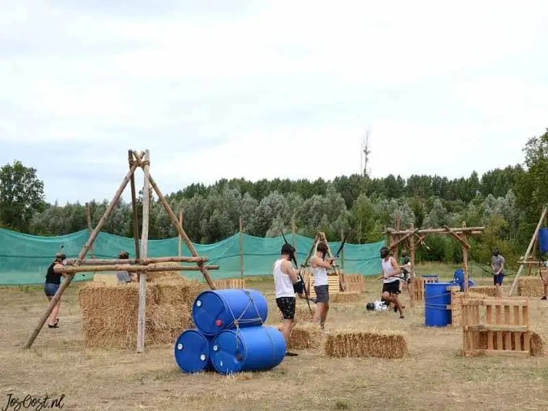 Kinderen bij hooibalen en andere hindernissen voor een soort paintbal achtig spel