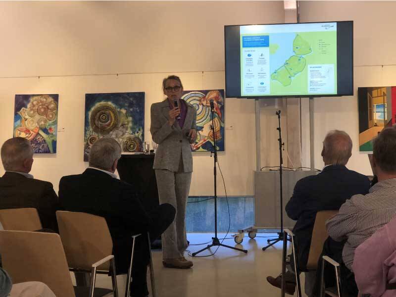 Dijkgraaf Klavers presenteert met behulp van een scherm aan het publiek in de Verbeelding