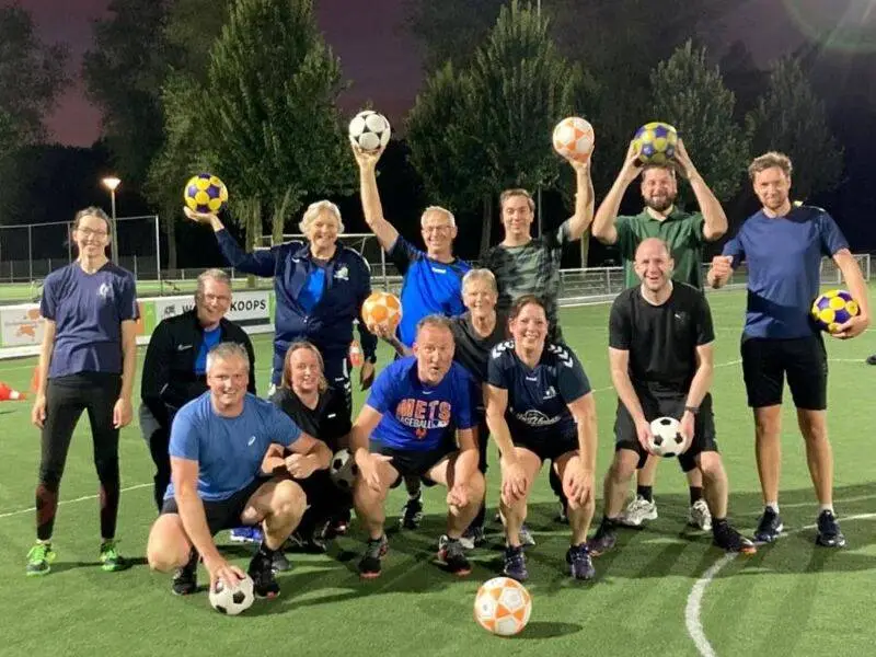 groepje mensen met sportkleding die verschillende korfballen vasthouden